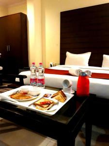 a tray of food on a table next to a bed at Hotel Chanakya inn in New Delhi