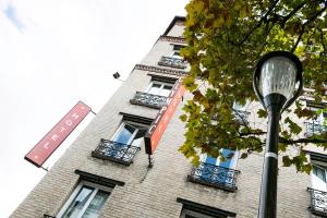 a tall brick building with windows and a street light at Hotel Olympic Paris Boulogne by Patrick Hayat in Boulogne-Billancourt