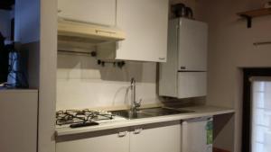 a white kitchen with a sink and a stove at Ai Filippini in Verona