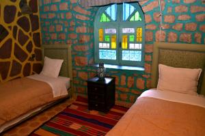 a room with two beds and a window at Riad Aslda in Asni
