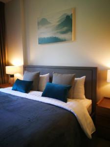 een slaapkamer met een groot bed met blauwe en witte kussens bij The Valley Khao Yai-2 Bed Room in Ban Huai Sok Noi