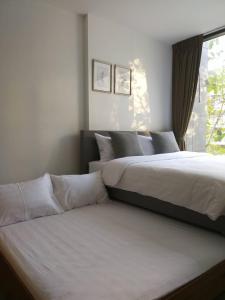 a bedroom with two beds and a window at The Valley Khao Yai-2 Bed Room in Ban Huai Sok Noi