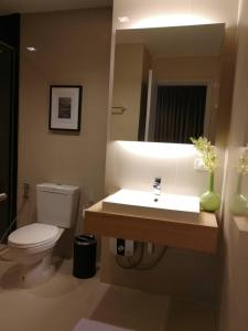 a bathroom with a toilet and a sink with a mirror at The Valley Khao Yai-2 Bed Room in Ban Huai Sok Noi