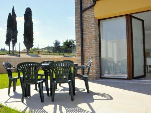cztery czarne krzesła i stół na patio w obiekcie Holiday Home in Lazise near Lake Garda w mieście Lazise