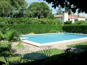a swimming pool in a yard with two tables and chairs at Modern Villa in Lazise with Private Pool in Lazise