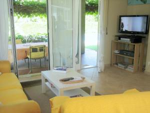 a living room with a couch and a table and a tv at Modern Villa in Lazise with Private Pool in Lazise