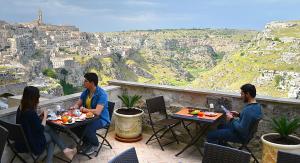 a group of people sitting at tables on a balcony at Il Belvedere in Matera