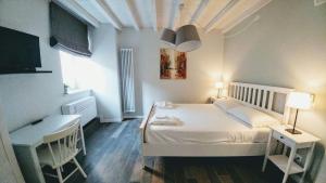 una camera da letto con un letto, una scrivania e una TV di Il Colle b&b a Tivoli
