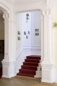 a stairway with white columns and a red carpet at Résidence de Tourisme Vacances Bleues Villa Regina in Arcachon