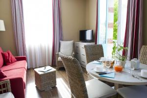 a living room with a table and a couch at Résidence de Tourisme Vacances Bleues Villa Regina in Arcachon