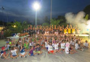 un gruppo di bambini che posano per una foto di notte di Camping Village Baia del Marinaio a Vada