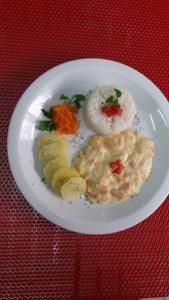 a plate of food with rice and vegetables on a table at Toulouse Motel (Adult Only) in Natal