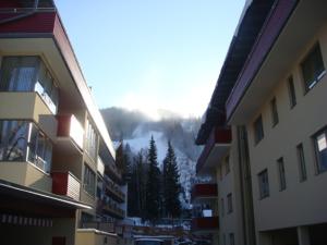 a view of a snowy mountain from between two buildings at Ski-In/Ski-Out Appartements Augasse by Schladming-Appartements in Schladming +6 photos