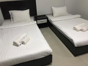 Dos camas en una habitación con toallas. en Home Rezidence Prachinburi en Si Maha Phot
