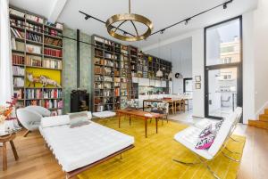 a living room with white furniture and bookshelves at Veeve - Saint-Lambert Deluxe in Paris