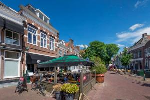 ハルリンゲンにあるHarlingen oldtown apartmentの緑傘を差す街路のカフェ