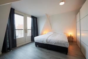 1 dormitorio con cama y ventana grande en Harlingen oldtown apartment, en Harlingen