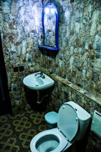 a stone bathroom with a toilet and a sink at Riad Aslda in Asni