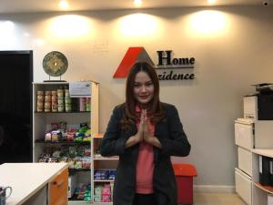 Una mujer parada en una tienda con las manos en alto en Home Rezidence Prachinburi en Si Maha Phot
