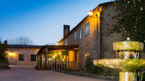 a stone building with a fountain in front of it at Casa do Cruceiro in As Galanas