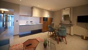 eine Küche und ein Wohnzimmer mit Tisch und Stühlen in der Unterkunft Atelier 24 in Sint-Pieters-Leeuw