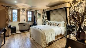 a bedroom with a large bed with a large headboard at Glenskirlie Castle Hotel in Banknock