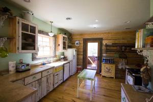 a kitchen with wooden walls and a wooden floor at Schoolhouse Cabin in Gardiner