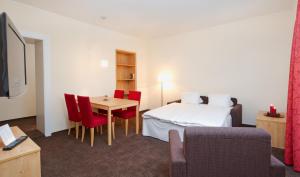 a hotel room with a bed and a table and chairs at Central Apartments Davos in Davos +15 photos