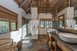 a bathroom with two sinks and two mirrors at Lalibela Game Reserve - Inzolo Lodge in Sidbury