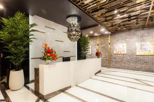 a lobby with plants and a chandelier at Hotel Platinia in Cluj-Napoca