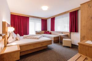 ゼルデンにあるApart Madeleine Superior inklusive Summercardのベッドとデスクが備わるホテルルームです。