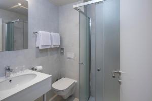 a bathroom with a toilet and a sink and a shower at Falkensteiner Hotel Park Punat in Punat