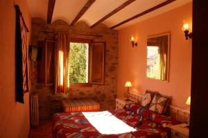 a bedroom with a bed and a couch and two windows at Casa Rural Uyarra in Ojacastro
