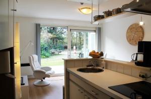 ホルムにあるGrutto in De Kaap 2 pのキッチン(シンク、椅子付)、窓が備わります。