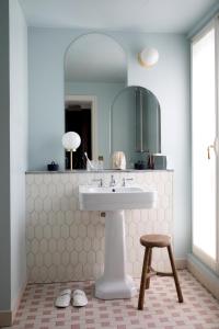 a bathroom with a sink and a stool and a mirror at Hotel des Grands Boulevards in Paris