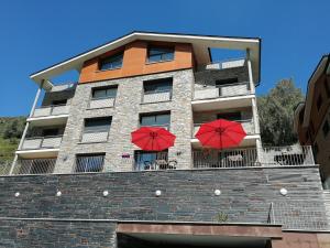 a building with two red umbrellas in front of it at Sol-Ski in El Tarter
