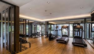 a gym with several treadmills in a room with windows at The Valley Khao Yai-2 Bed Room in Ban Huai Sok Noi