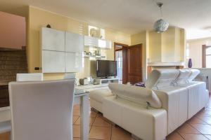 a living room with a white couch and chairs at Anaelehouserooms LTB in Arborea