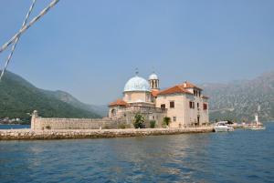 a building on a island in the water at Apartmani Villa Radovic in Risan