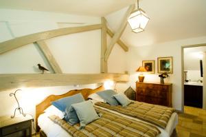 a bedroom with a large wooden bed with blue pillows at La Ferme de Marie Eugénie in Bruailles