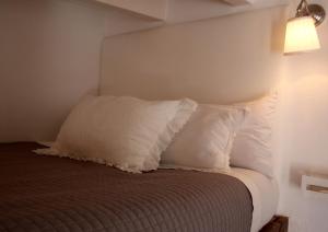 a bed with two pillows on it in a room at Casa Rosa Garden House in Santa Cristina d'Aro