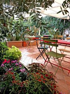 een patio met een tafel, stoelen en planten bij La Foresteria Garden Boutique B&B in Catania