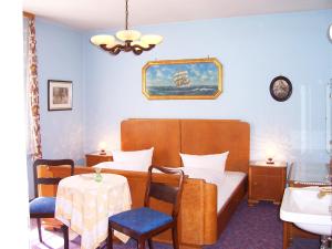 a hotel room with a bed and a table and chairs at Hotel Krone in Gößweinstein +51 photos