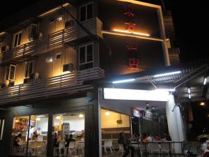 a building with people sitting outside of it at night at Oriental Inn in Kuching