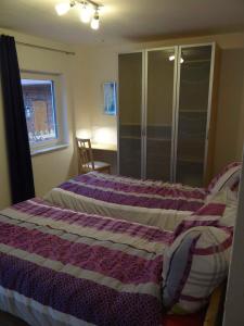 a bedroom with two beds and a cabinet and a window at Hof Sonnengold in Osterholz-Scharmbeck