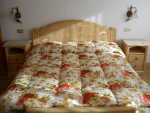 サッパーダにあるAppartamenti Annaritaの花柄の布団が敷かれたベッド