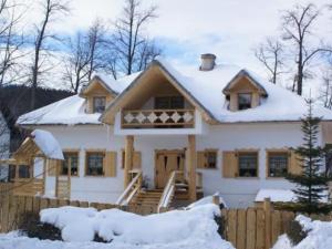 a white house with snow on the roof at Dworek Karpacz in Karpacz