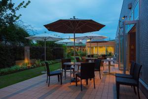 桐生市的住宿－桐生大酒店，一个带桌椅和遮阳伞的庭院