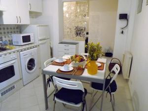 una piccola cucina con tavolo, sedie e forno a microonde di House Fede by Holiday World a Genova