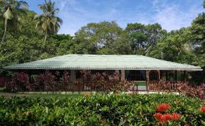 una casa con techo verde en un jardín en La Jorará en Palomino